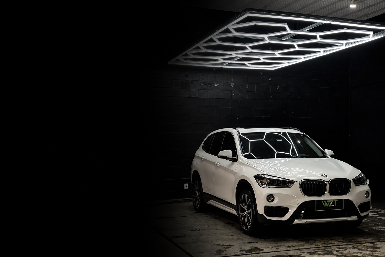 BMW branco dentro da WZT Studio com iluminação neon refletida sobre a pintura